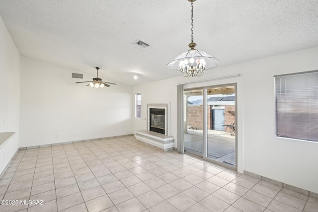 unfurnished living room with lofted ceiling, light tile patterned floors, ceiling fan with notable chandelier, and a textured ceiling