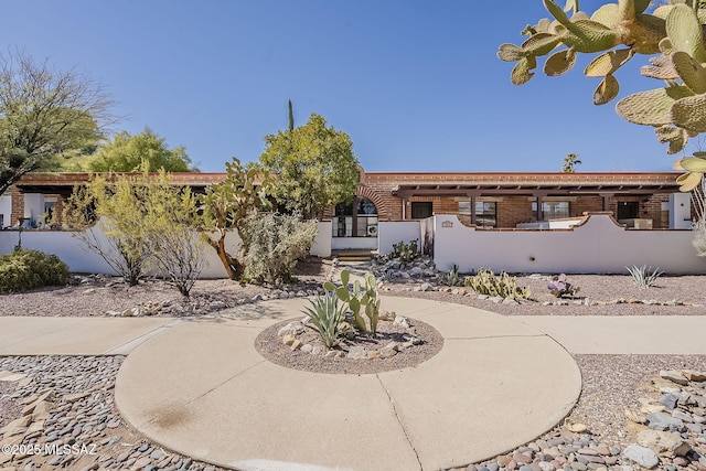 exterior space featuring curved driveway and fence