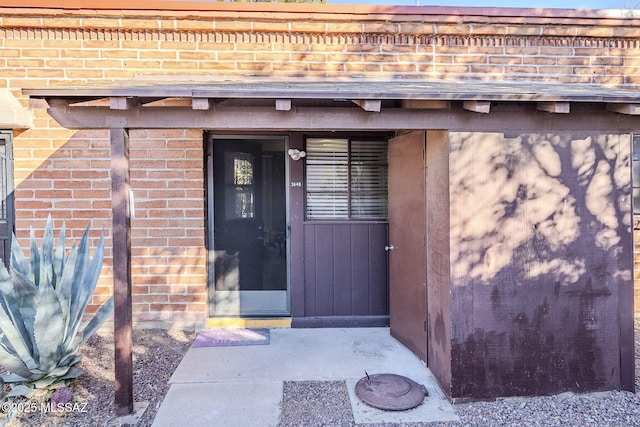 view of exterior entry with brick siding