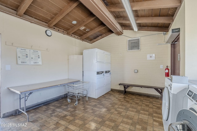 community laundry room with stacked washer / drying machine, wooden ceiling, and baseboards