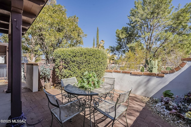 view of patio featuring outdoor dining space and fence