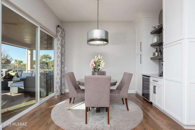 dining space featuring a dry bar, wine cooler, and dark wood-type flooring