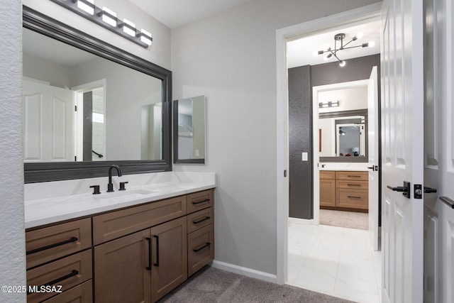 bathroom featuring marble finish floor, vanity, and baseboards