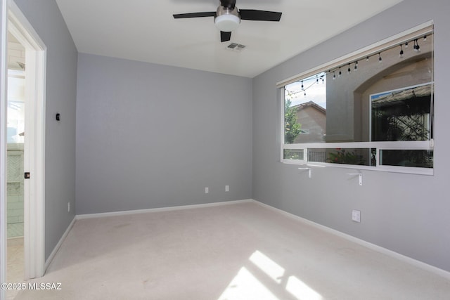 unfurnished room featuring light colored carpet, ceiling fan, visible vents, and baseboards