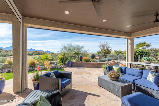 view of patio with a ceiling fan, a fenced backyard, a mountain view, and an outdoor living space