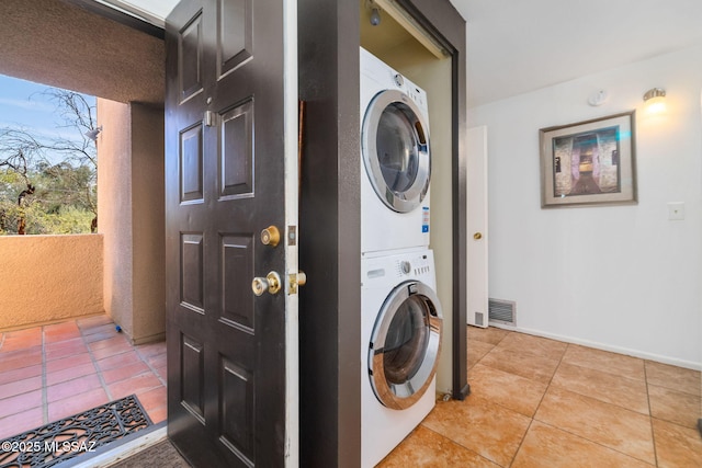 washroom featuring light tile patterned floors and stacked washer and clothes dryer