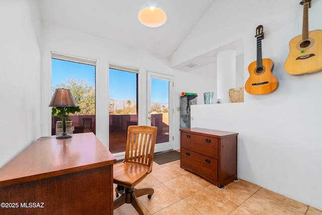 office space with light tile patterned floors, lofted ceiling, and a healthy amount of sunlight