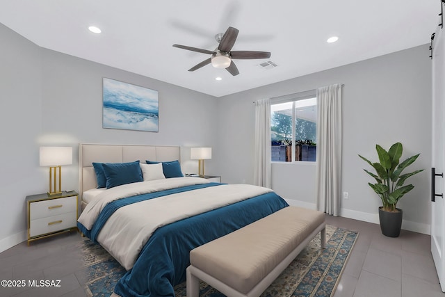 bedroom featuring a barn door and ceiling fan