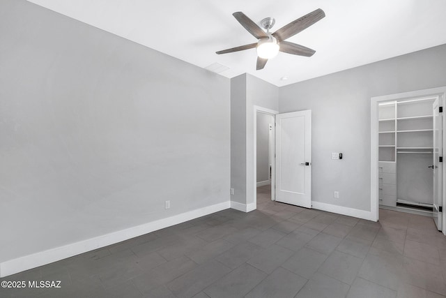 unfurnished bedroom featuring ceiling fan, a spacious closet, and a closet