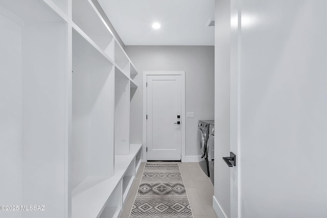 mudroom with light tile patterned flooring and washer and dryer