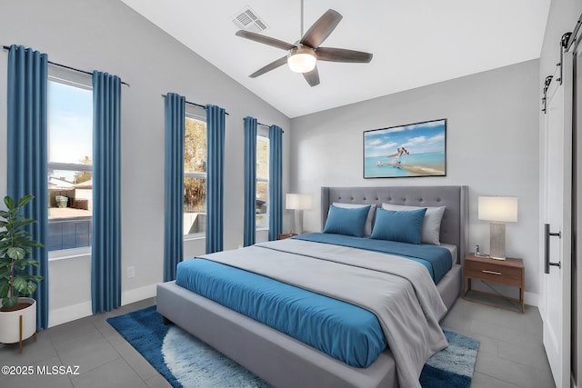 tiled bedroom featuring vaulted ceiling, a barn door, and ceiling fan