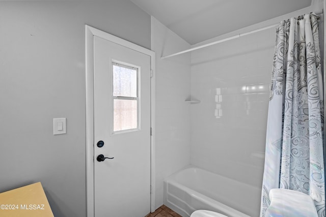 bathroom with shower / bath combo with shower curtain and toilet