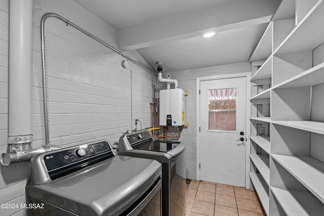 washroom with tankless water heater, separate washer and dryer, and light tile patterned flooring