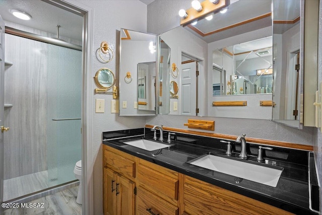 3873 W Allred St, Thatcher, AZ 85552 - bathroom with a stall shower, toilet, double vanity, a textured wall, and wood finished floors