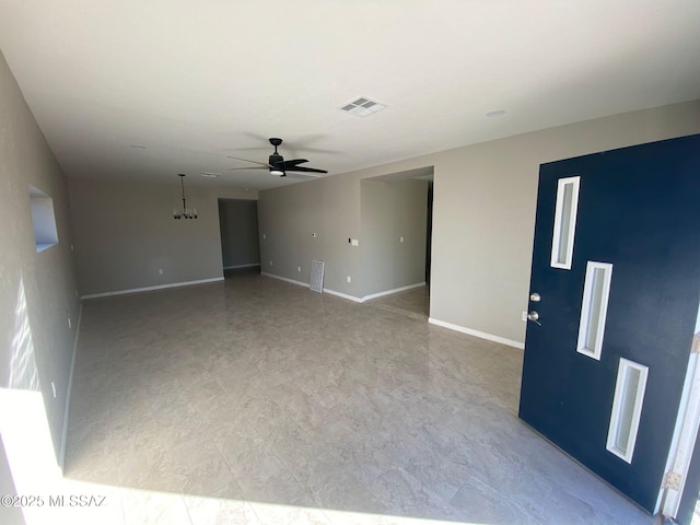 empty room with ceiling fan with notable chandelier