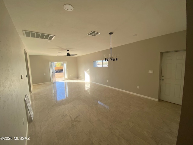 unfurnished room featuring ceiling fan with notable chandelier