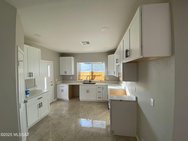 kitchen featuring white cabinets and sink