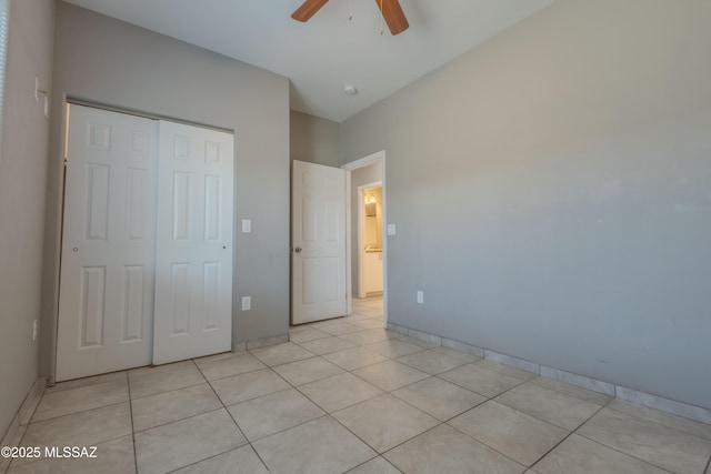 unfurnished bedroom featuring light tile patterned floors, ceiling fan, and a closet