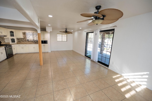 tiled spare room featuring ceiling fan and sink