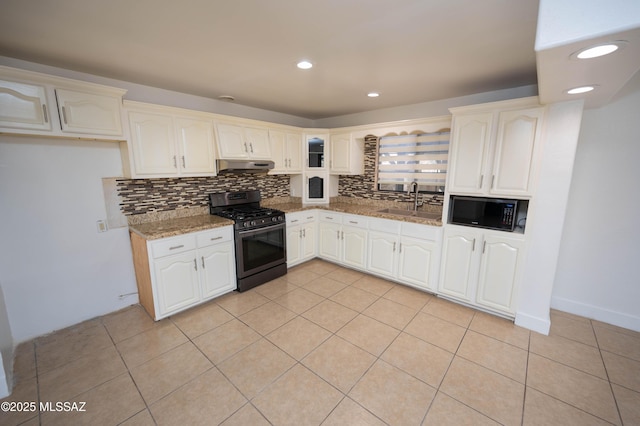 kitchen featuring white cabinets, black microwave, dark stone counters, sink, and stainless steel range with gas cooktop