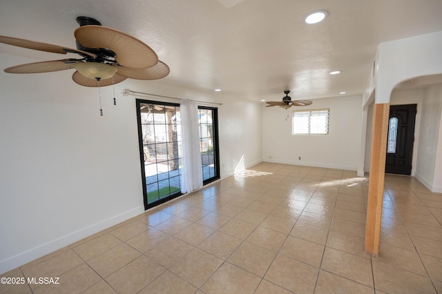 tiled spare room featuring ceiling fan