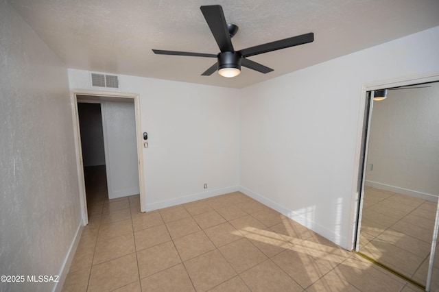 tiled empty room with a textured ceiling and ceiling fan