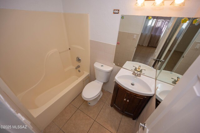 full bathroom featuring tile patterned floors, vanity, shower / washtub combination, tile walls, and toilet