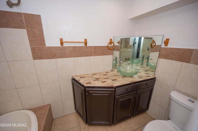 bathroom featuring tile patterned floors, tile walls, toilet, and vanity