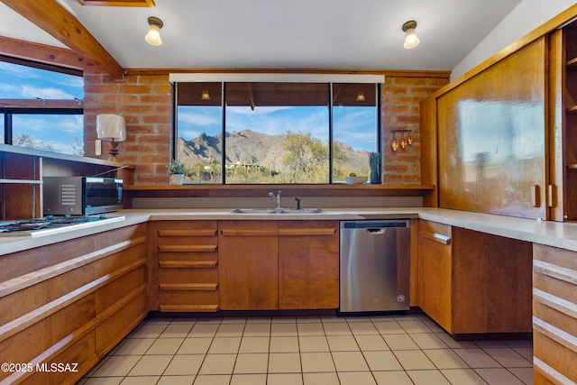 kitchen featuring stainless steel appliances, brown cabinetry, light countertops, and a mountain view