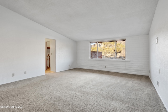 empty room featuring lofted ceiling and light colored carpet