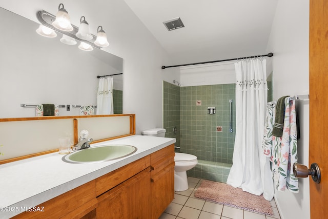 full bath with toilet, visible vents, vanity, a tile shower, and tile patterned floors