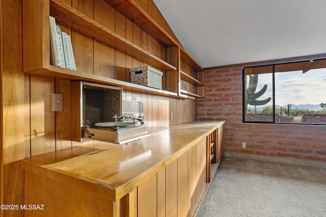 home office with carpet floors and brick wall