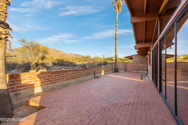 view of patio featuring fence and a mountain view