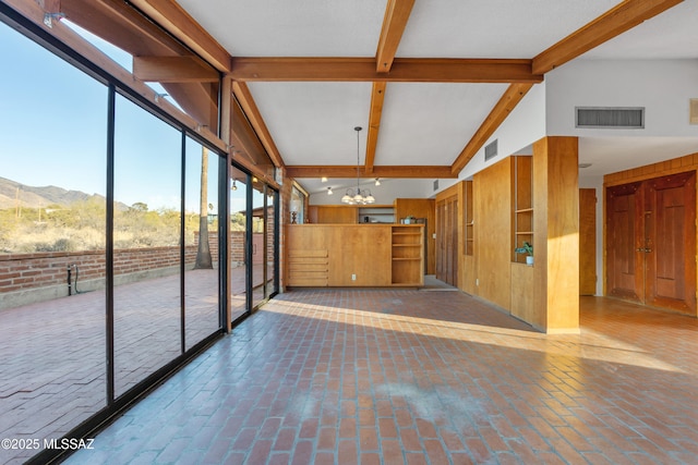 unfurnished sunroom featuring a mountain view, vaulted ceiling with beams, visible vents, and a notable chandelier