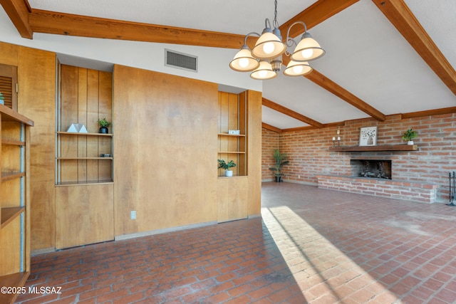 unfurnished living room with lofted ceiling with beams, brick floor, visible vents, a brick fireplace, and an inviting chandelier