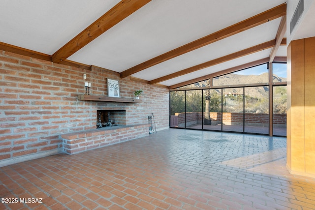 unfurnished living room with vaulted ceiling with beams, a brick fireplace, a mountain view, and brick floor