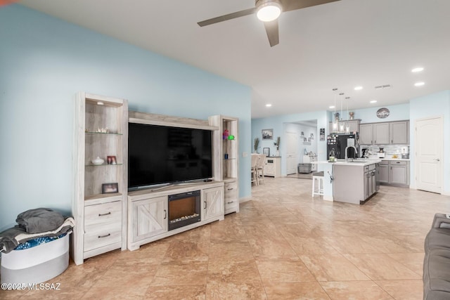 living room with ceiling fan and sink