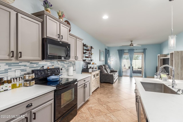 kitchen with sink, gray cabinetry, black appliances, decorative backsplash, and decorative light fixtures