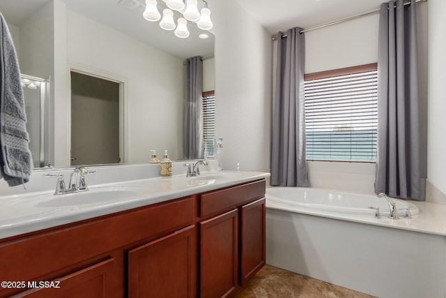 bathroom with tile patterned floors, a tub to relax in, and vanity