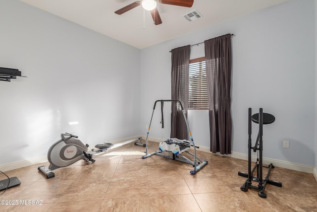 exercise area with ceiling fan and light tile patterned flooring