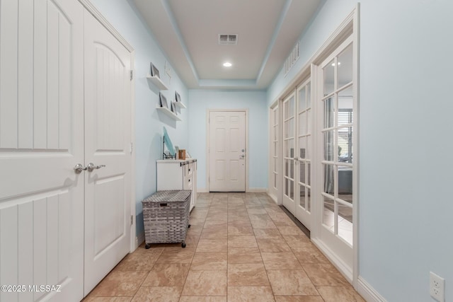 doorway to outside with french doors and a raised ceiling