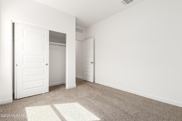 unfurnished bedroom with a closet and carpet flooring