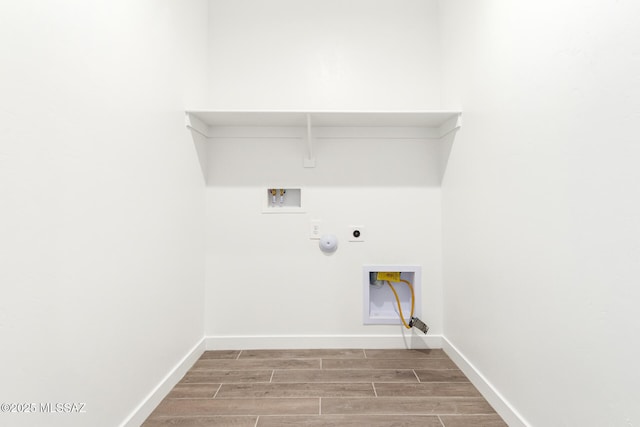 laundry room with hookup for a washing machine, wood-type flooring, electric dryer hookup, and hookup for a gas dryer