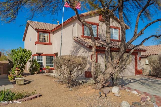 mediterranean / spanish home featuring driveway, a tile roof, and stucco siding