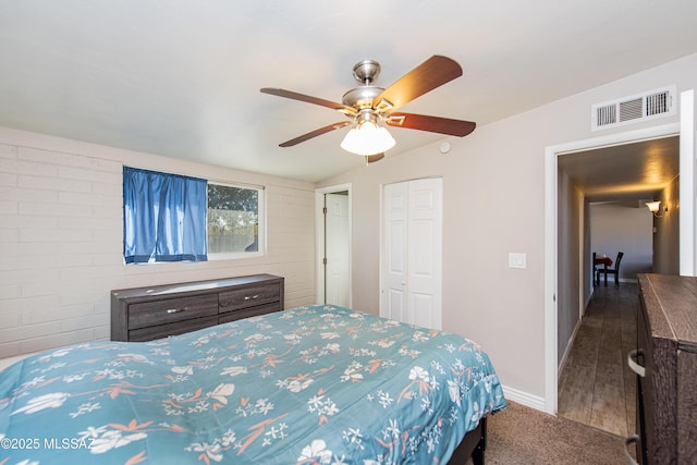 carpeted bedroom with ceiling fan and a closet