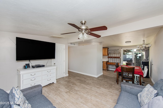 living room featuring light hardwood / wood-style floors and ceiling fan with notable chandelier