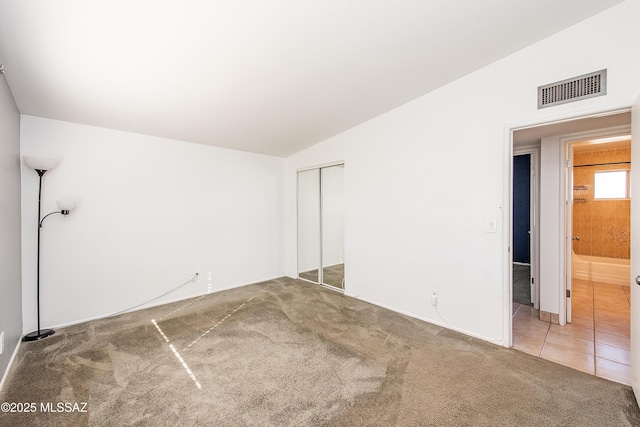 spare room with carpet flooring and lofted ceiling