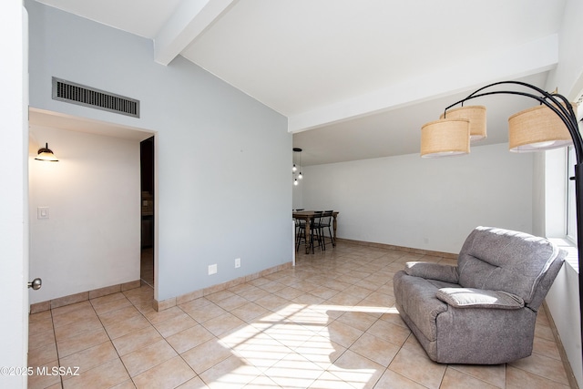 sitting room featuring light tile patterned floors and vaulted ceiling with beams