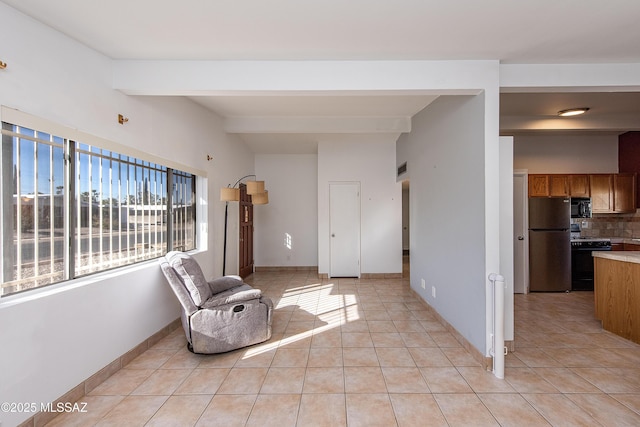 living area featuring beam ceiling and light tile patterned flooring