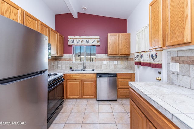 kitchen with tasteful backsplash, sink, tile countertops, and stainless steel appliances